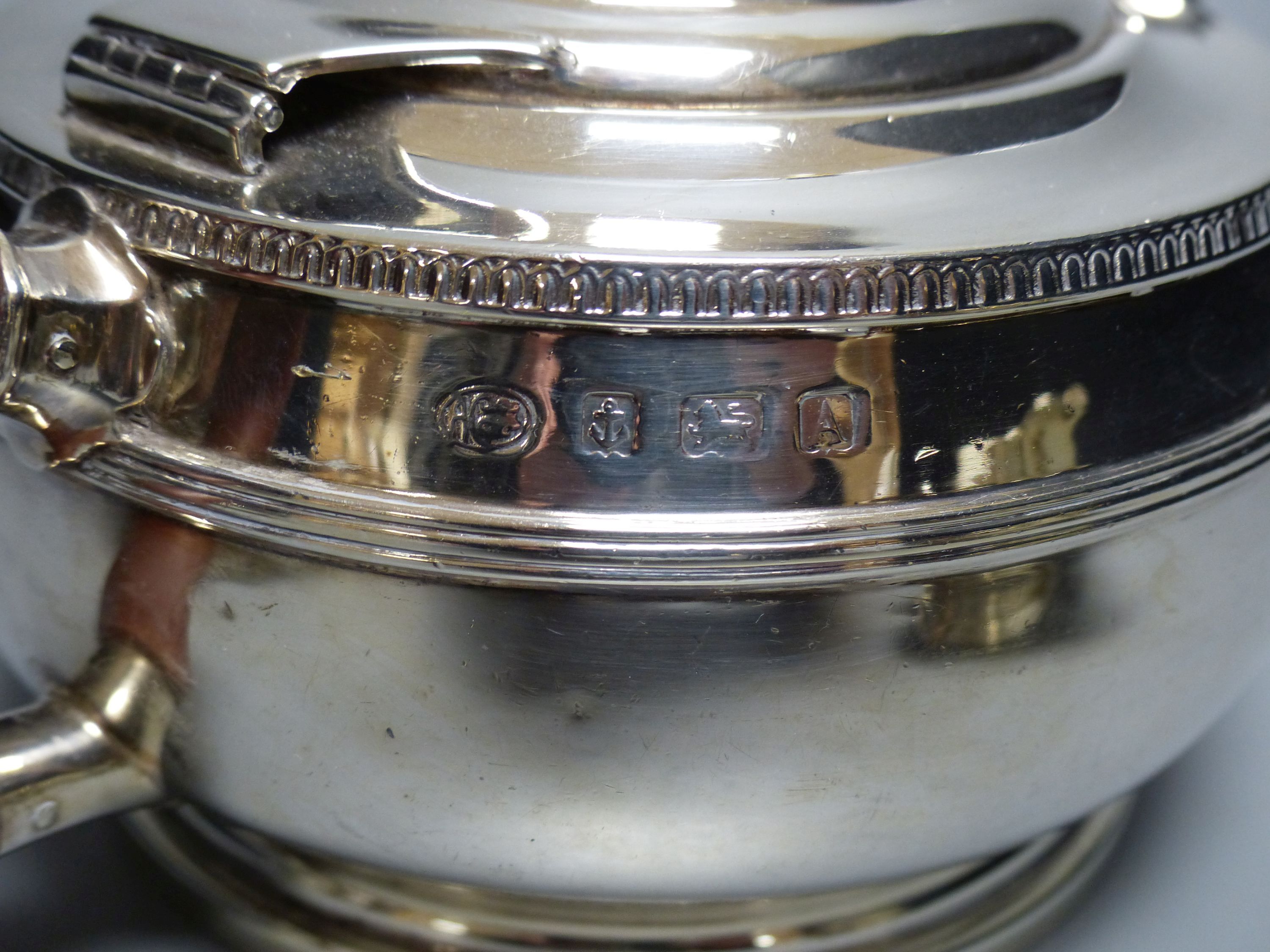 A matched silver three-piece tea service of squat reeded circular form, gross 28.25oz